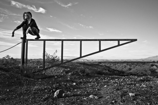 Cris Crotz poses for a photo in the Arizona Desert atop a metal gate